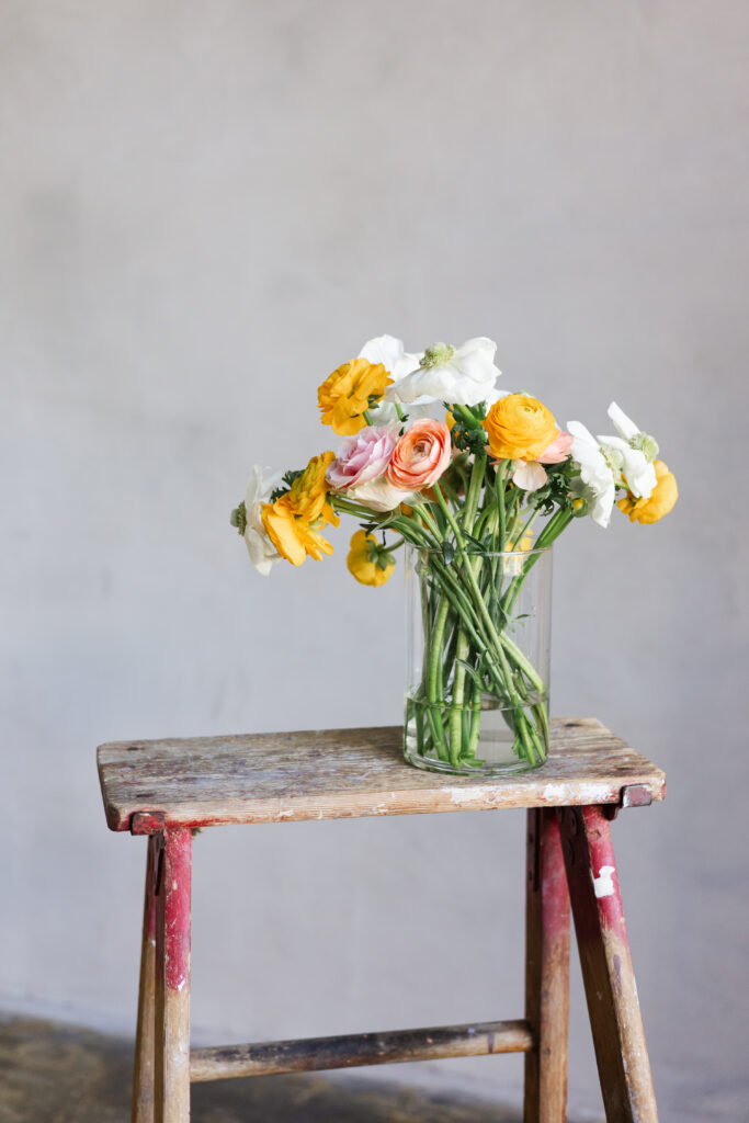 Close-up of a wooden ladder styled with a glass vase of fresh florals, symbolizing growth, creativity, and an editorial aesthetic for women entrepreneurs.